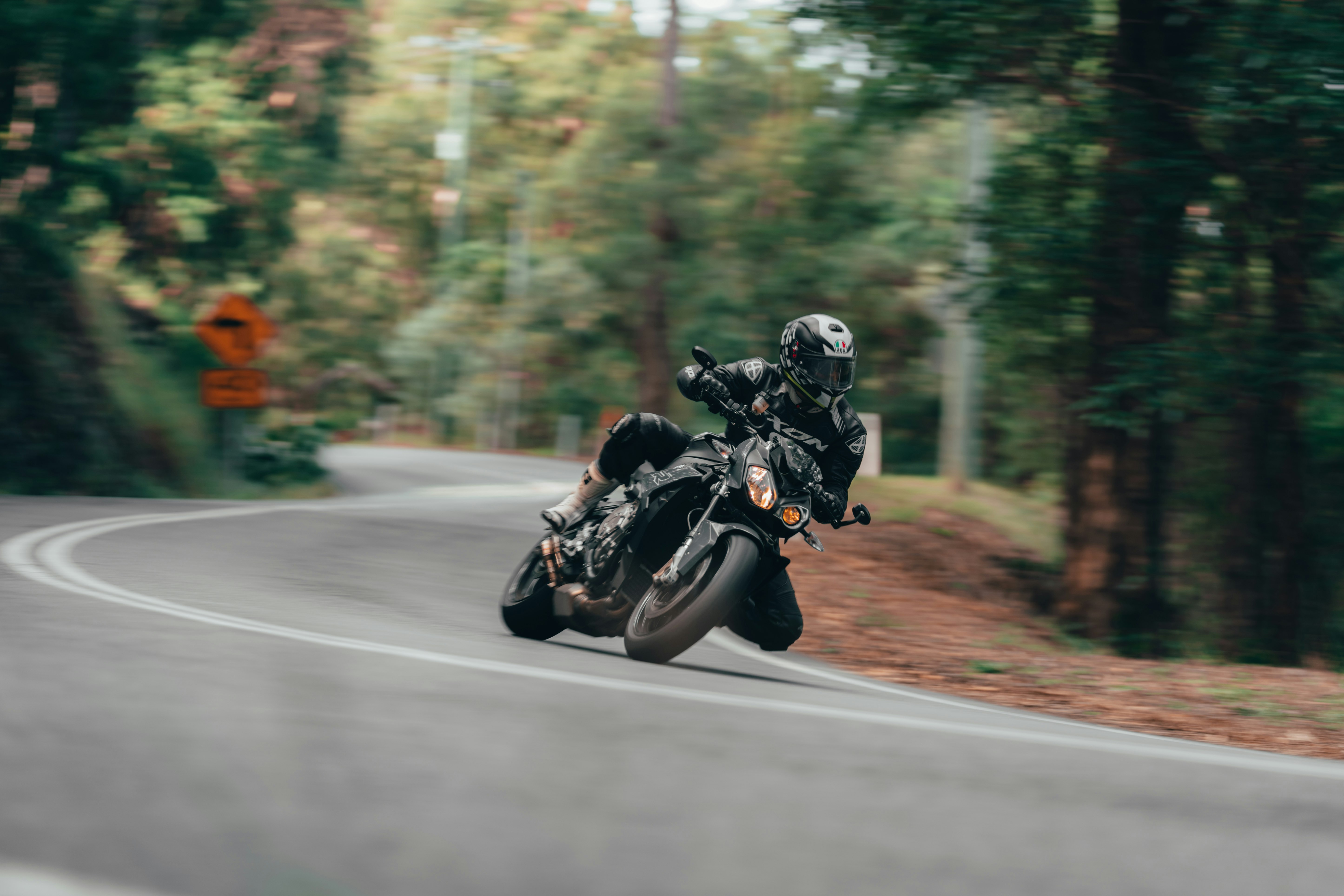 man in black motorcycle helmet riding motorcycle on road during daytime